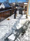Nathan plowing snow off the deck to make a racetrack for his little racecars