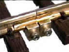 Picture of little brass clamps that hold the tracks tightly together